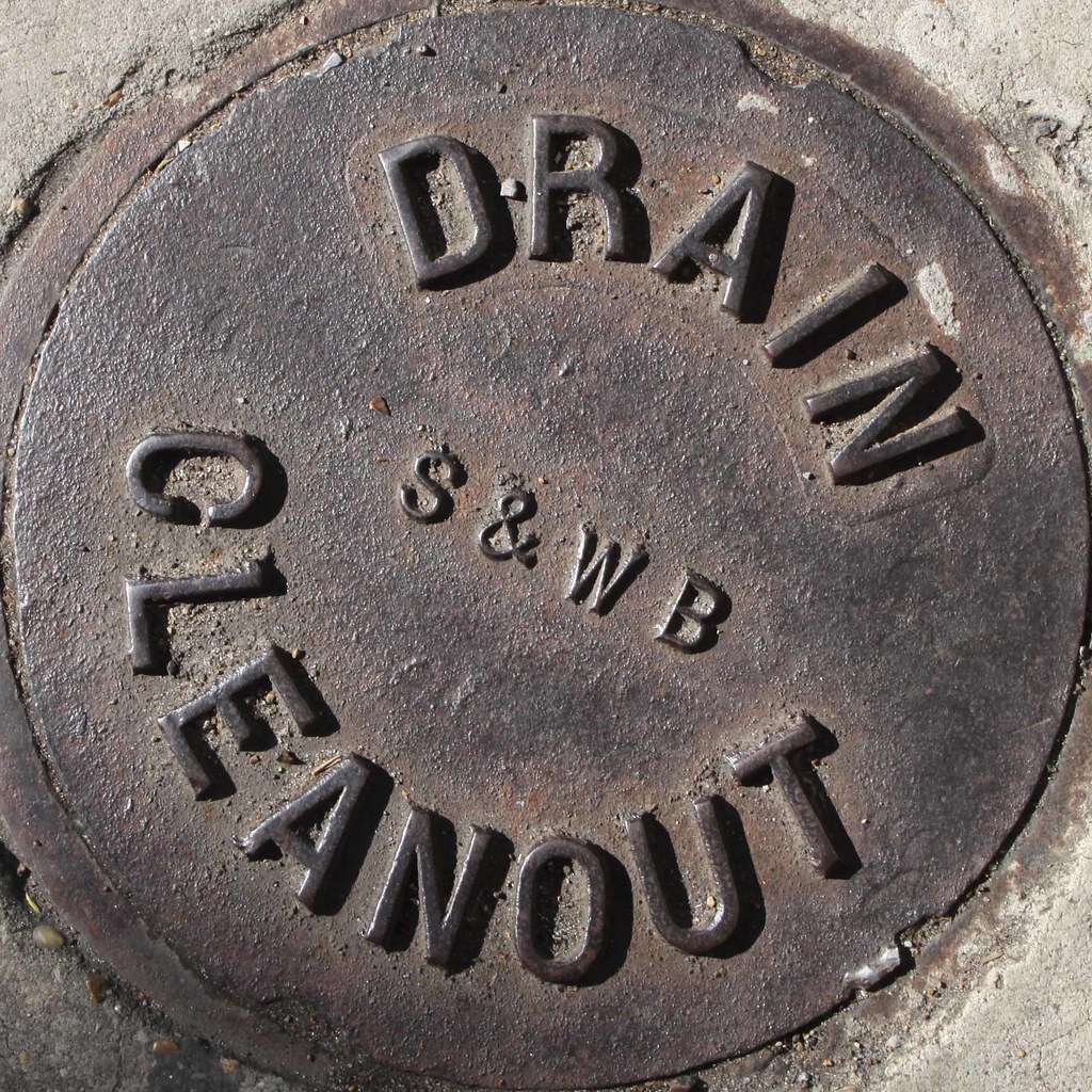 Cast iron drain cleanout cover set in concrete